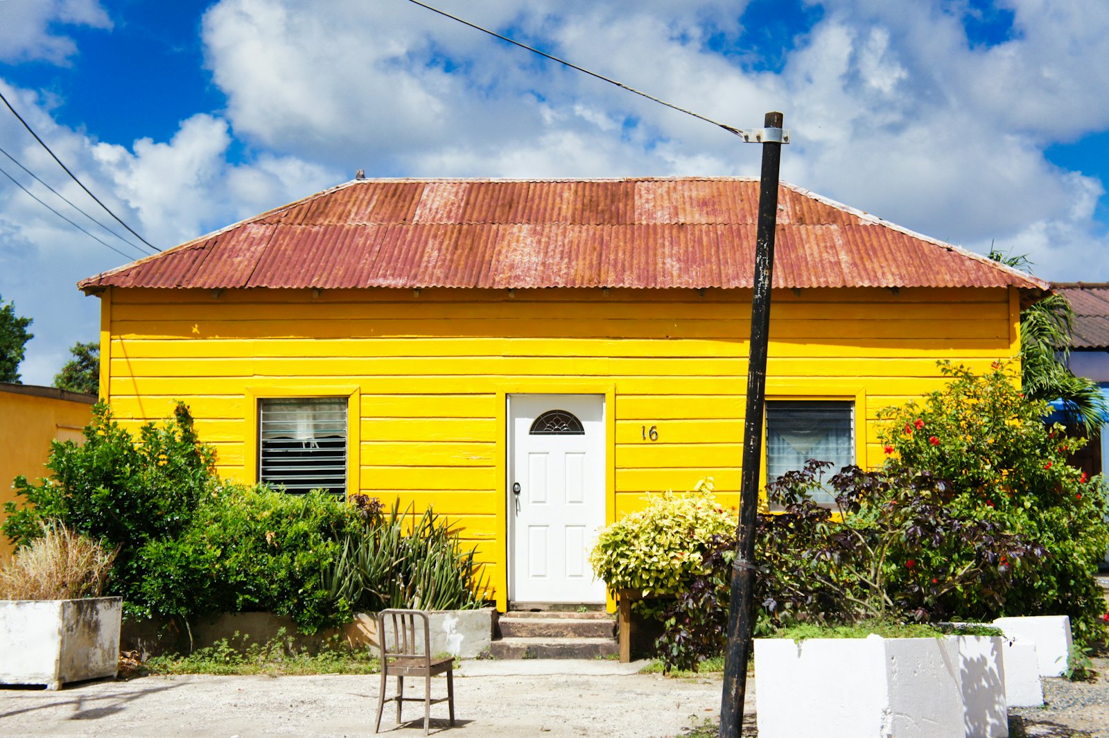 A small yellow house with a tin roof